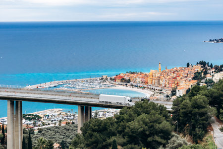 Picturesque view of Menton's city center with colorful historic buildings and the blue sea surrounding the townの写真素材