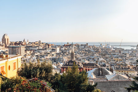 View of Genoa's rooftops at sunset, showcasing the cityâs historic skyline and warm golden light.の写真素材