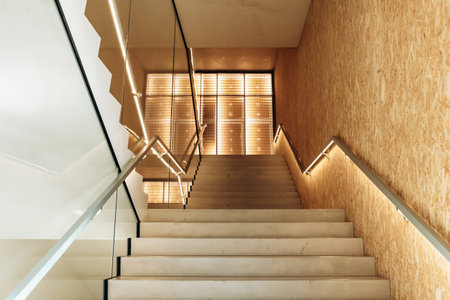 Milan, Italy - March 19, 2025 : Minimalist staircase with glass and wood details inside Fondazione Prada Torreのeditorial素材