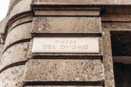 Piazza del Duomo street sign on stone wall in central Milanの写真素材