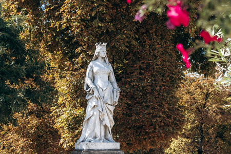 Paris, France â September 12, 2025: Marble statues stand among lush autumn trees in the historic city park - Luxembourg Gardenの写真素材