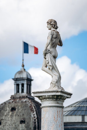 Marble statue in Luxembourg Gardens with domed roof in the background.の写真素材