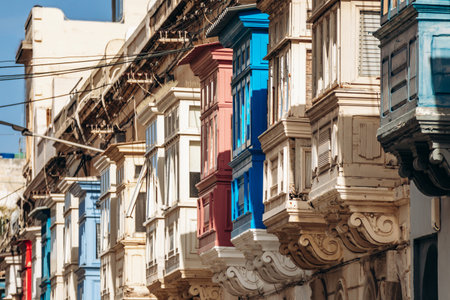 Traditional Maltese wooden balconies painted in vibrant colors on limestone facades, typical architecture of the historic city center.の写真素材