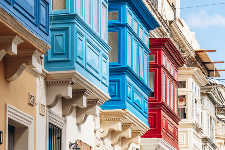 Traditional Maltese wooden balconies painted in vibrant colors on limestone facades, typical architecture of the historic city center.の写真素材