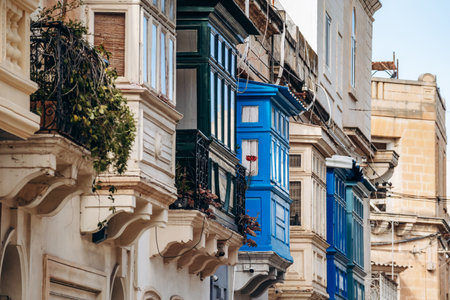 Traditional Maltese wooden balconies painted in vibrant colors on limestone facades, typical architecture of the historic city center.の写真素材