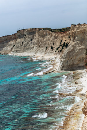 White limestone cliffs and bright turquoise Mediterranean waters along the coastline between Marsaskala and Marsaxlokk, Maltaの写真素材