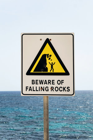 Warning sign on a rocky coastal trail between Marsaskala and Marsaxlokk, Malta, cautioning about...