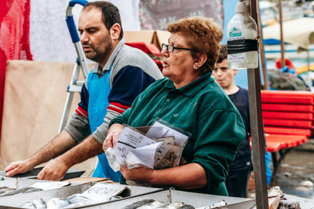 Marsaxlokk, Malta - April 13, 2025: Local fish market vendors selling fresh seafood at outdoor stalls during the traditional Sunday market in the fishing village of Marsaxlokkのeditorial素材
