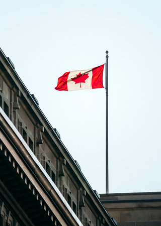 Montreal, Canada - August 11, 2025: Canadian flag on a historic building facade in downtown Montreal, Quebecの写真素材