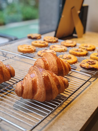 Nice, France â€“ March 22, 2025: Freshly baked golden croissants and artisanal cookies...