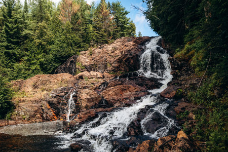 Scenic waterfall flowing over rocky terrain in Parc des Chutes de la Petite Riviere Bostonnais in...