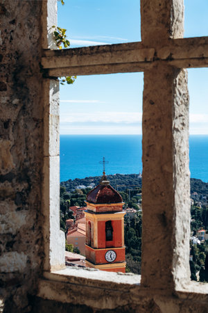Bell tower of Sainte Marguerite Church seen through a stone window of Grimaldi Castle overlooking...