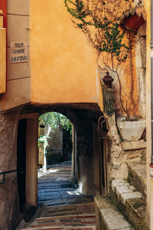 Roquebrune-Cap-Martin, France - February 9, 2025: Narrow picturesque alley with stone arch and colorful facades in the medieval village of Roquebruneのeditorial素材
