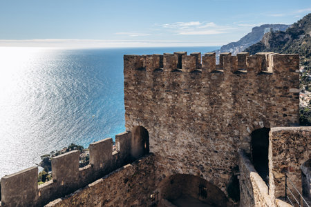Stone walls and battlements of Grimaldi Castle overlooking Roquebrune village, Mediterranean coast and Monacoのeditorial素材