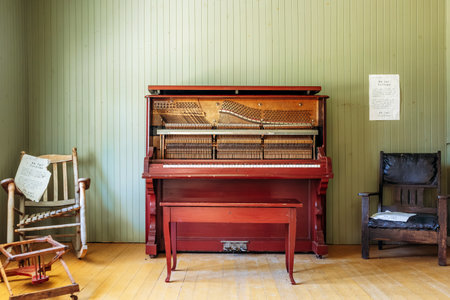 Chambord, Canada - August 18, 2025: Restored 1927 house interior with exposed upright piano mechanism at Val-Jalbert Historical Village in Quebecのeditorial素材