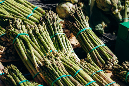 Fresh green asparagus bundles displayed for sale at Liberation market in Niceの写真素材