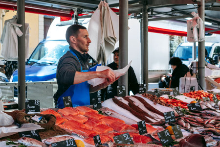 Nice, France - March 23, 2025: Fishmonger selling fresh seafood at the Liberation street market on a Sunday morningのeditorial素材