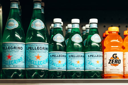 Montreal, Canada - August 14, 2025: A closeup view of bottles of S Pellegrino sparkling mineral water neatly arranged on a grocery store shelf, alongside bright orange Gatorade Zero bottlesのeditorial素材