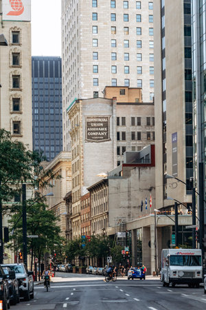 Montreal, Canada - August 14, 2025: A busy downtown street in Montreal with historic facades, modern towers  and cars, showing the vibrant mix of old and new architecture in the city centerのeditorial素材