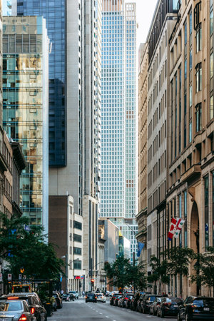 Montreal, Canada - August 13, 2025: financial district street canyon with modern skyscrapers and Canadian-Quebec flagsのeditorial素材