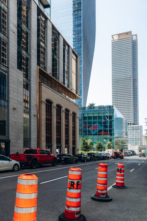 Montreal, Canada - August 14, 2025: A view of downtown Montreal featuring modern skyscrapers and bright orange construction cones on the streetのeditorial素材