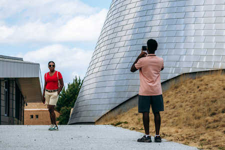 Montreal, Canada - 14 August 2025: Visitors taking photos near the modern metal structures of the...