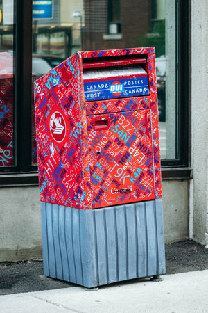 Montreal, Canada â August 15, 2025: Canada Post mailbox covered with colorful stickers in downtown Montrealのeditorial素材