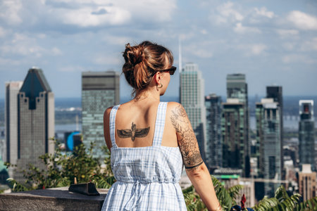 Montreal, Canada - August 15, 2025: Person with tattoos standing at Kondiaronk Belvedere overlooking the city skylineのeditorial素材