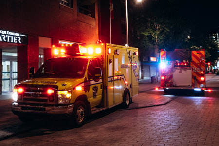 Montreal, Canada - August 15, 2025: Emergency ambulance and fire truck with flashing lights in downtown Montrealのeditorial素材