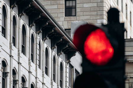 Downtown historic building facade with arched windows and red traffic light in foreground