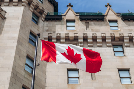 Ottawa, Canada - August 13, 2025: Canadian flag in front of the Fairmont Chateau Laurier facade in...