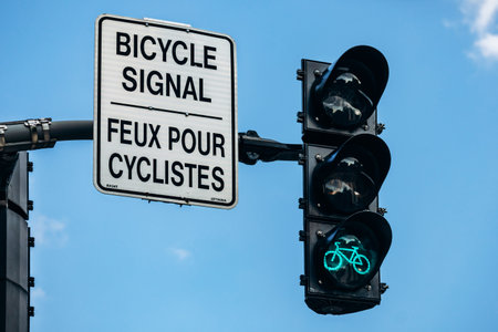 Ottawa, Canada - August 13, 2025: Bicycle traffic signal in downtown Ottawa with a bilingual road...