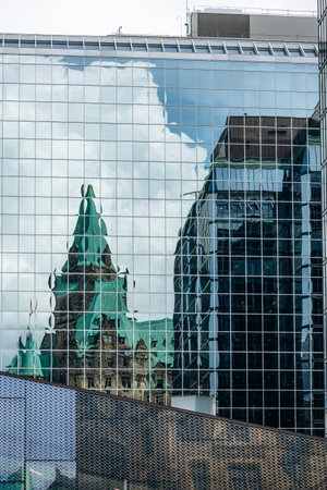 Ottawa, Canada - August 13, 2025: Reflection of the historic Confederation Building in the glass facade of a modern office tower in downtown Ottawaのeditorial素材