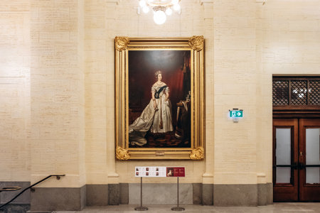Ottawa, Canada - August 13, 2025: Full length state portrait of Queen Victoria in a white gown with sash, displayed in a large gilded frame inside the Senate of Canada Building in Ottawa.のeditorial素材
