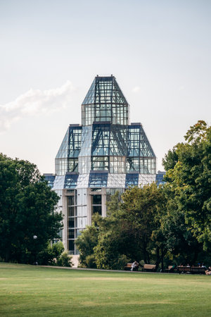 Ottawa, Canada - August 13, 2025: View of the National Gallery of Canada glass and steel building rising above a green lawn and trees in downtown Ottawa on a sunny summer day.のeditorial素材