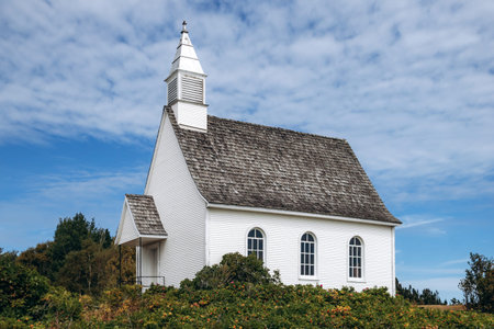 Port-au-Persil, Canada - August 20, 2025: Small white wooden chapel with bell tower overlooking the...