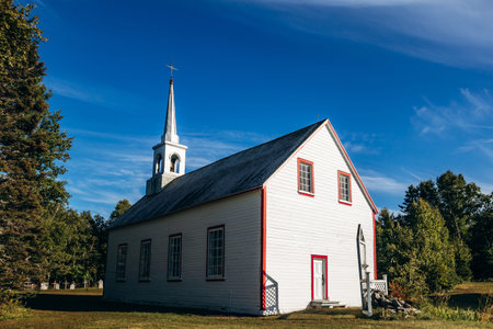 White wooden church building at Village historique de Saint Firmin (Saint Firmin Historic Village), a preserved heritage site representing traditional rural Quebec architecture in Baie-Sainte-Catherineの写真素材