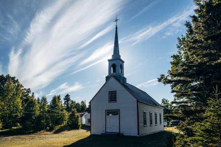 White wooden church building at Village historique de Saint Firmin (Saint Firmin Historic Village), a preserved heritage site representing traditional rural Quebec architecture in Baie-Sainte-Catherineの写真素材