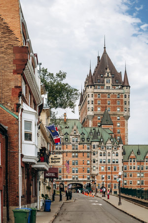 Quebec City, Canada - August 23, 2025: Fairmont Le Chateau Frontenac castle hotel with turrets overlooking Terrasse Dufferin boardwalk, stone walls and tourists strolling on summer dayのeditorial素材
