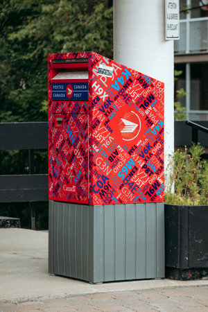 Quebec City, Canada - August 23, 2025: Red Canada Post mailbox with graphic lettering design on a...