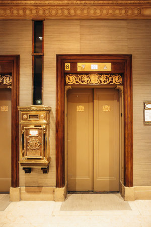 Quebec City, Canada - August 23, 2025: Ornate wooden elevator doors numbered 8 with brass plaque and decorative trim at Fairmont Le Chateau Frontenac hotel interior hallwayのeditorial素材
