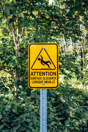 Yellow warning sign in French at Parc de la Chute Montmorency warning about slippery surface when...