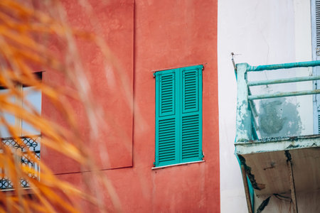 Colorful historic facade with turquoise shutters on a traditional building in the old town of Menton...