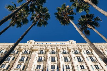Cannes, France - September 15, 2025: facade of the Carlton Cannes luxury hotel with palm trees on...