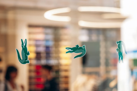 Cannes, France - September 15, 2025: Lacoste crocodile logos displayed on the window of a Lacoste...