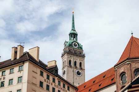 Munich, Germany - April 15, 2025: View of the clock tower of St Peter's Church (Alter Peter) rising above historic buildings in the center of Munich, Bavaria, Germanyのeditorial素材