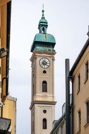 Munich, Germany - April 15, 2025: View of St Peter Church tower with clock and green copper dome rising between historic buildings in the old town of Munich, Bavaria, Germanyのeditorial素材