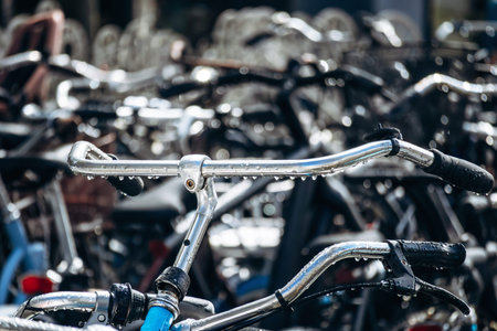Large number of parked bicycles on a city street in central Amsterdam, highlighting everyday cycling culture and urban transportation