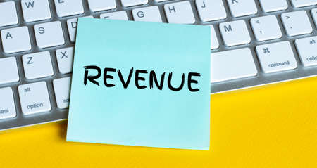 Word writing text REVENUE. Business concept for situation in which an employee works mainly from home Note paper taped to black computer screen near keyboard and stationary.の写真素材