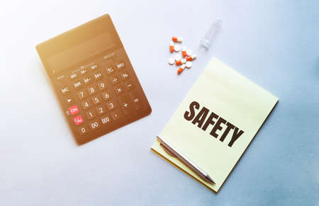 Economic calculation of the cost of treatment, analysis of the cost of medicines. Bottle of pills, calculator on blue background. Top viewの写真素材